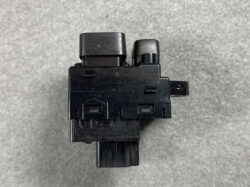 Black plastic electronic module with two cylindrical tops and a bottom connector, viewed from the side/top.