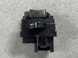 Top-down view of a black plastic electrical switch/relay module with a small lever and mounting tabs, showing a textured surface and a stamped number 4417SN on the front.