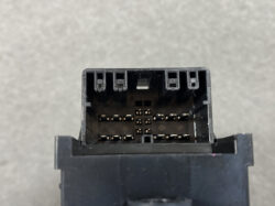 Close-up of a black rectangular automotive multi-pin connector with two rows of small metal pins, shown from the front.