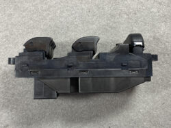 Automotive multi-function switch assembly with two black stalk levers mounted on a plastic housing, seen from above.