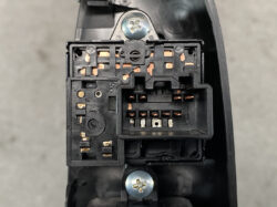 Close-up of an automotive electrical connector block with copper terminals and mounting screws.