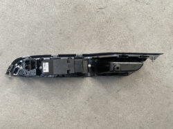 Car door window switch and mechanism assembly with electrical connectors on a gray concrete floor