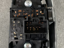 Close-up of a black plastic multi-pin electrical connector with copper contacts inside a device.