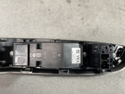 Automotive electrical control unit with a multi-pin connector on the right, mounted in a black plastic housing