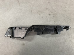 Long black automotive interior trim panel with mounting clips and screws, likely a dash/console piece used to secure panels in place.