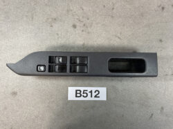 Car door panel with four power window switches, a window lock button, and a recessed door pull area on the right.