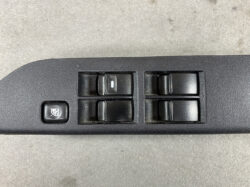 Power window control panel with four switches and a child lock button on the left (car door surface)