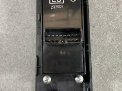 Close-up of a rectangular two-row multi-pin automotive connector in black plastic housing, gold contacts visible.