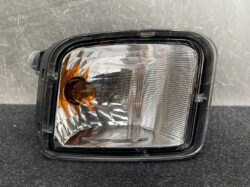 Rectangular car headlight assembly with a clear lens and amber turn signal section on the left side.