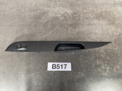 Black car door panel with a recessed door handle area and window switch