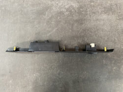 Long black automotive switch rail with multiple connectors and yellow clips, likely a window/lock control module.