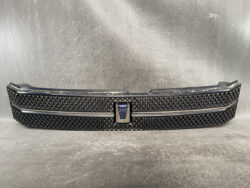 Front black car grille with a diamond mesh pattern and a central VOXX emblem.