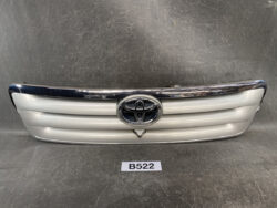 Front view of a silver Toyota car grille with chrome trim and emblem in the center