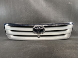Front grille of a silver Toyota car with emblem center
