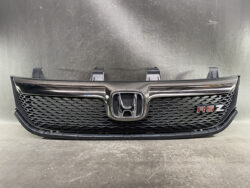 Front view of a Honda grille with black honeycomb mesh and chrome surround, featuring the Honda emblem at center and an RSZ badge on the right