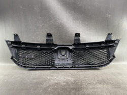 Front bumper grille assembly with honeycomb mesh and mounting brackets for a vehicle’s front end.