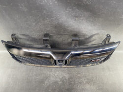 Honda front grille assembly with chrome wing and RS badge, showing mounting brackets and honeycomb pattern on the lower grille.