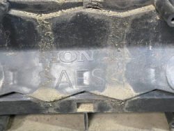 Close-up of a dusty Honda engine component with the embossed HONDA logo and the letters AES.