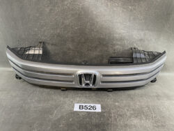 Front grille/bumper component for a Honda car, silver with black trim and Honda emblem at center, photographed on a dark surface