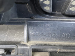 Close-up of a dusty car interior panel showing embossed Honda part numbers: 71121-TV8 BASE FR GRILLE, base front grille area.