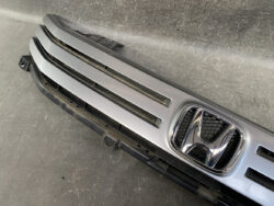 Front grille of a Honda vehicle featuring the chrome Honda emblem and silver horizontal slats