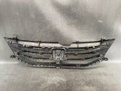 Front car grille assembly with Honda emblem removed, showing upper and lower grille slats and mounting points.