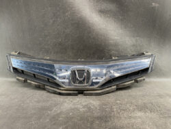 Front view of a chrome Honda grille with the emblem centered on a black stand (auto part).