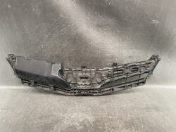 Black plastic car bumper/fascia rear undertray component laid on a textured surface, showing mounting clips and cutouts