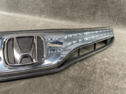Close-up of a chrome Honda front grille with the H emblem and a row of LED daytime running lights along the side panel.