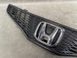Front grille of a black car with a chrome Honda emblem at the center