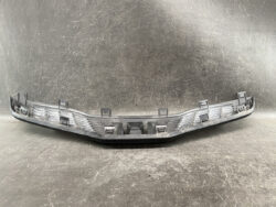 Curved gray plastic car bumper cover with multiple mounting clips on the edges.
