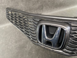 Close-up of a car's front grille with the chrome Honda emblem centered.