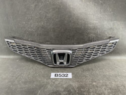 Front grille of a Honda car with a chrome honeycomb mesh and central Honda emblem