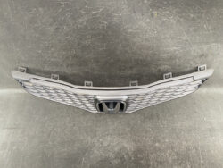 Front grille assembly for a Honda vehicle with a central Honda badge and diamond mesh pattern, shown against a dark surface.