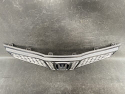 Front grille with a large Honda emblem and honeycomb pattern, likely a car grille assembly.