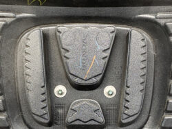 Close-up of a textured black foot pedal with wavy grip edges and two silver screws.