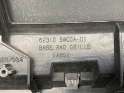 Close-up of black plastic automotive base for a radiator grille, with embossed part number 62310 5WC0A-01 and ABS material label.