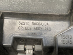 Close-up of a Nissan radiator grille assembly with embossed part numbers 62310 and 62312.