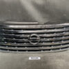 Front grille of a Nissan vehicle with chrome horizontal slats and the circular Nissan emblem in the center. NISSAN NOTE E12 NE12 Genuine Radiator Grille 62310-3VA0A / 62312-3VA0A » JDM-PARTS NZ