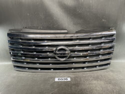Front grille of a Nissan vehicle with chrome horizontal slats and the circular Nissan emblem in the center.