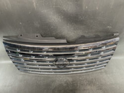 Chrome Nissan front grille with emblem centered, mounted on a black plastic backing plate.
