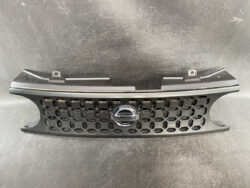 Nissan front grille with a hexagonal honeycomb mesh and the Nissan badge in the center