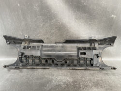 Plastic front bumper piece with a hexagonal honeycomb grille and mounting tabs.