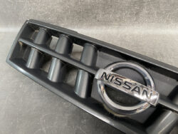 Close-up of a Nissan emblem on a black car grille