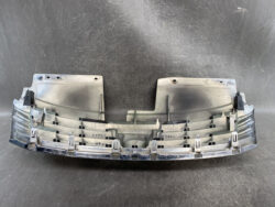 Curved grey automotive dashboard trim with multiple mounting clips and vent housings, shown from the back side.