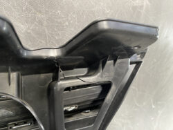 Close-up of a black plastic mounting bracket with a visible crack at the hinge.