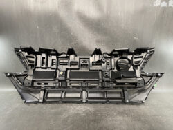 Black plastic automotive dashboard back panel with mounting tabs and cutouts for gauges and controls.