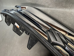 Close-up of glossy chrome roof rack crossbars with black mounting feet on a vehicle roof.