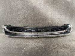 Front car grille with black honeycomb pattern and chrome trim against a gray background