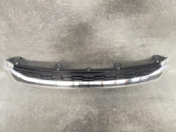 Curved automotive LED daytime running light strip with black housing, laid on a gray workshop floor.